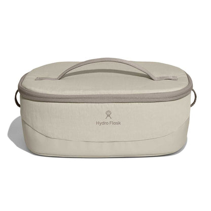 Beige Hydro Flask oval insulated bag with zip-around lid, fabric top handle, short side handles, and centered logo. Slightly structured base.